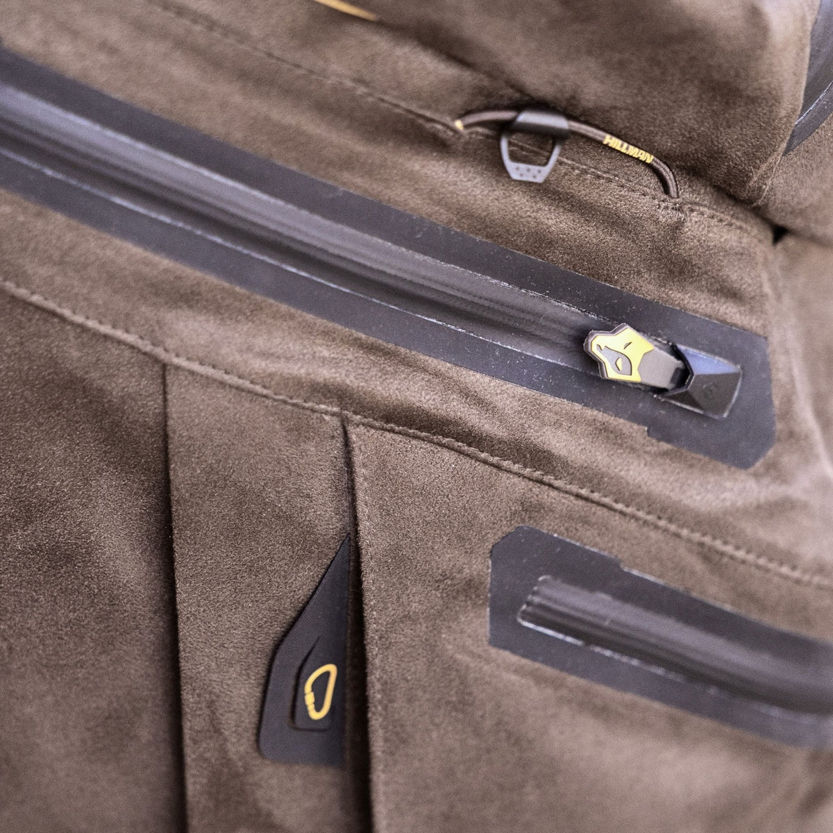 Close-up of a brown suede jacket with a water-resistant zipper and gold-black pull tab - pairs perfectly with Hillman's Insulated Winter Pants for ultimate outdoor winter comfort. The soft, textured material adds style and warmth.