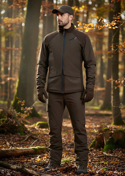 A man wearing the Fusion Hunting Jacket stands in a sunlit forest with fallen leaves and trees in the background.